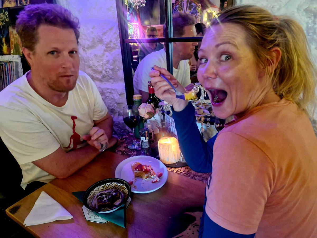 Two diners tucking into dessert, one pulling a delighted face