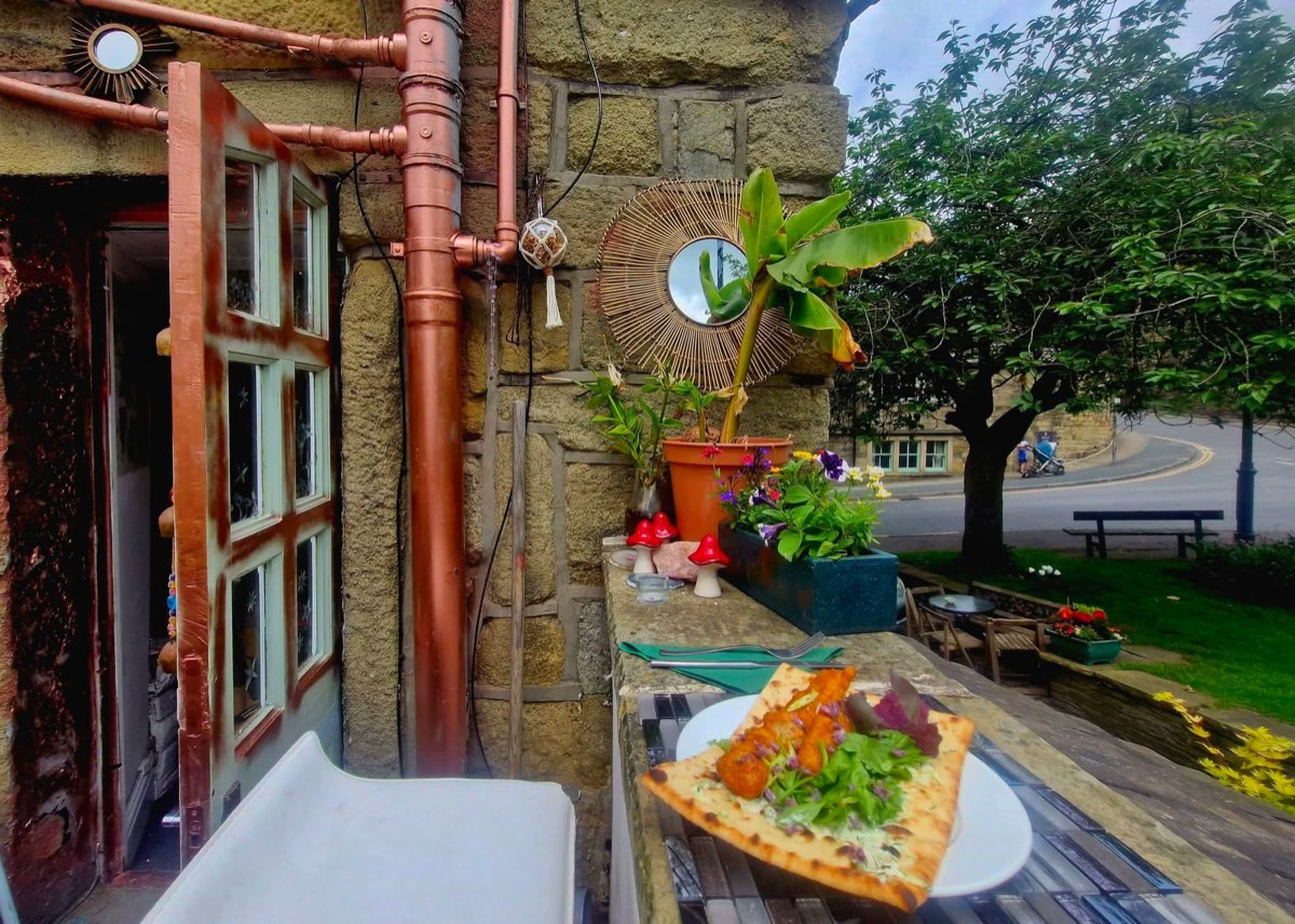 Flatbread on the outdoor ledge by the copper pipes and open door