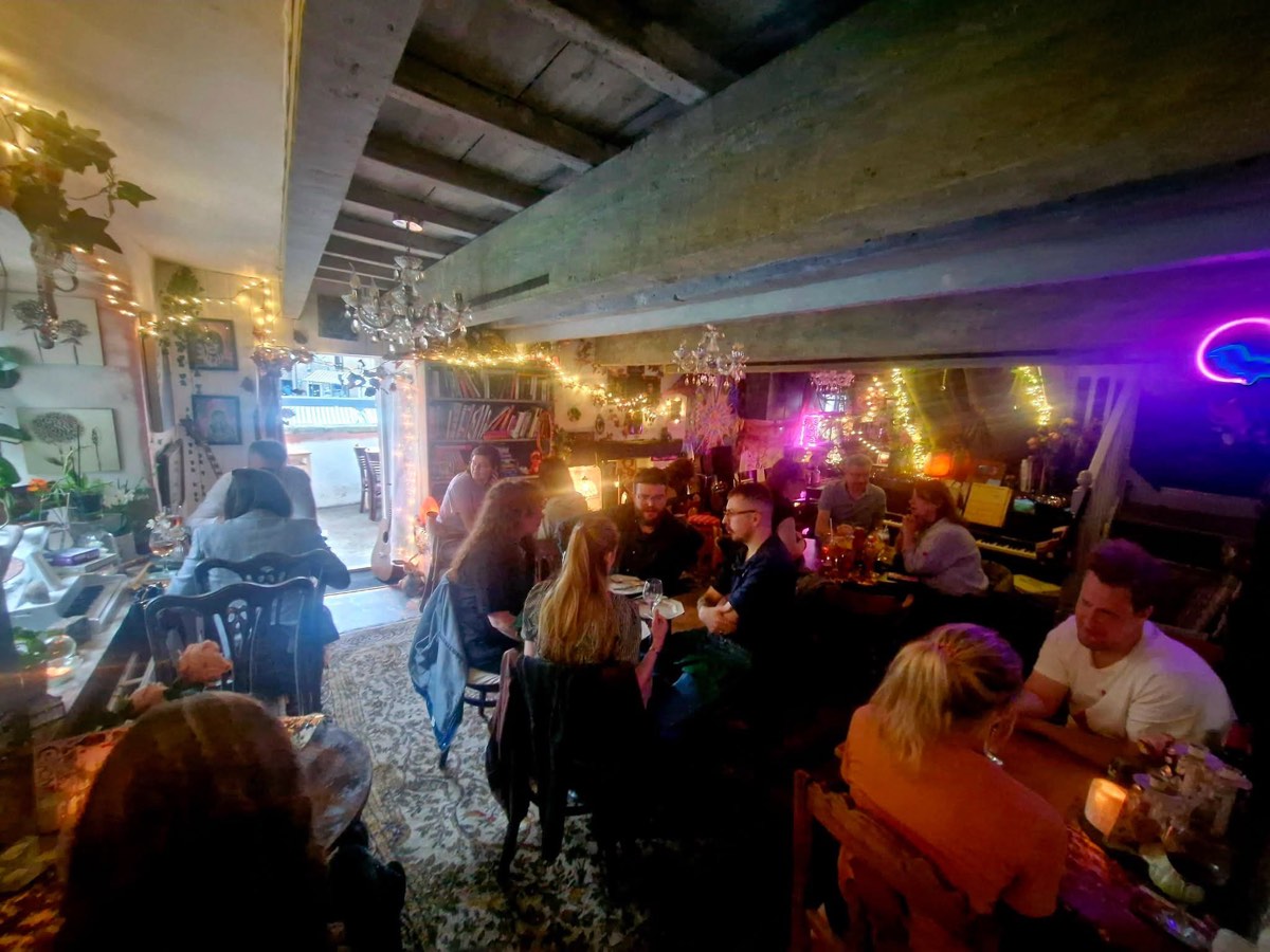The candlelit dining room full on a busy evening, chandeliers and fairy lights overhead